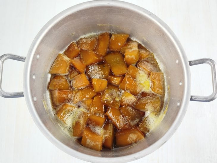 Doce pronto, com calda espessa, cubos caramelizados e coloração intensa.