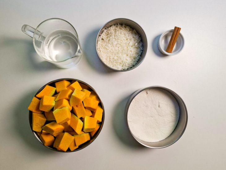 Ingredientes organizados sobre a bancada com a abóbora cortada em cubos grandes.