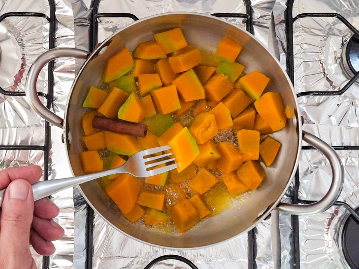 Abóbora cozinhando na panela até ficar macia e com pouca água.