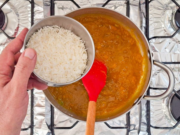 Coco em flocos sendo acrescentado ao doce ainda quente.