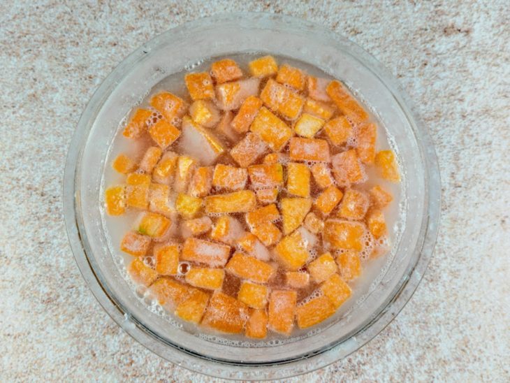 Pedaços de abóbora adicionados na tigela com cal dissolvido em água.