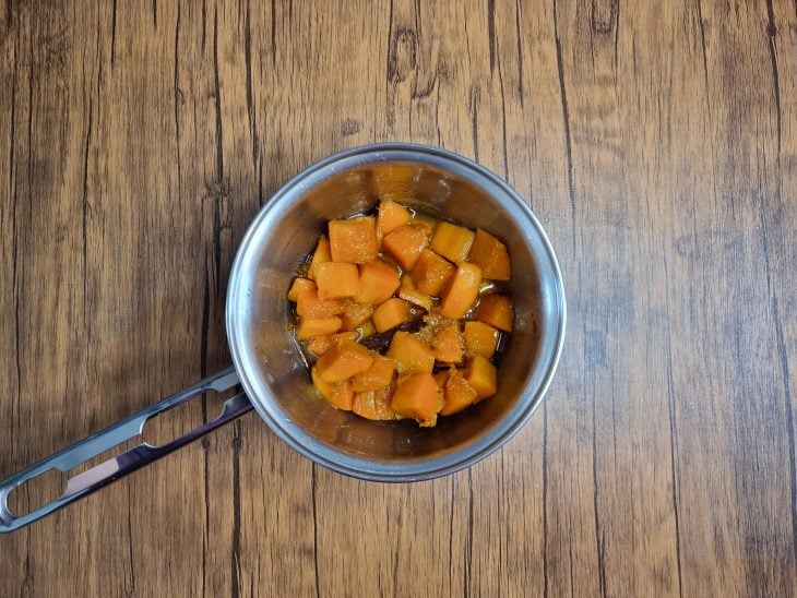 Uma panela contendo doce de abóbora em pedaços.