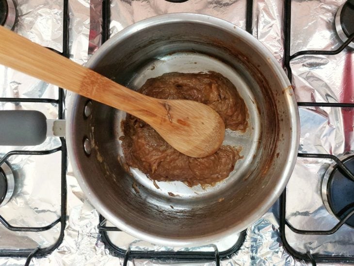 Um recipiente com bananas picadas em processo de caramelização.