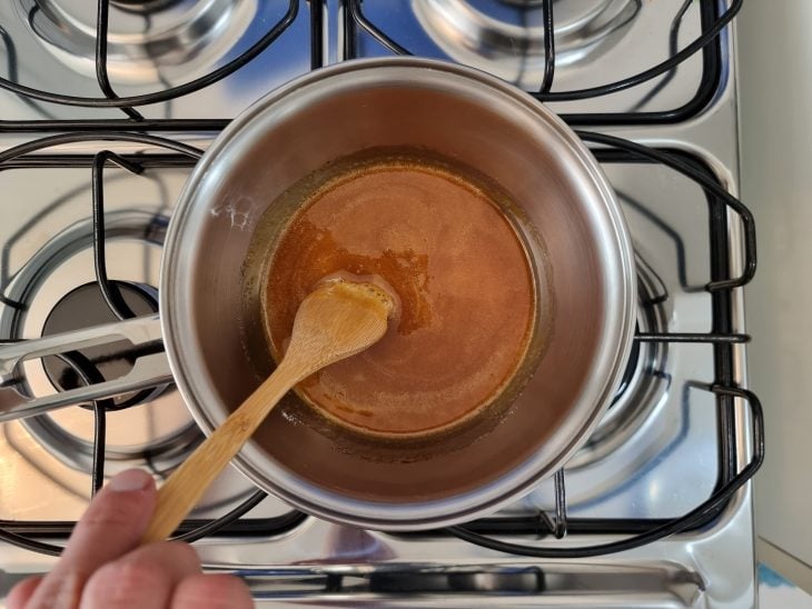 Panela com açúcar derretido com textura e cor de caramelo.