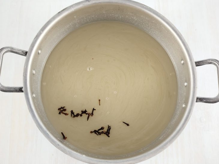 Figos sendo cozidos em panela grande com água quente.