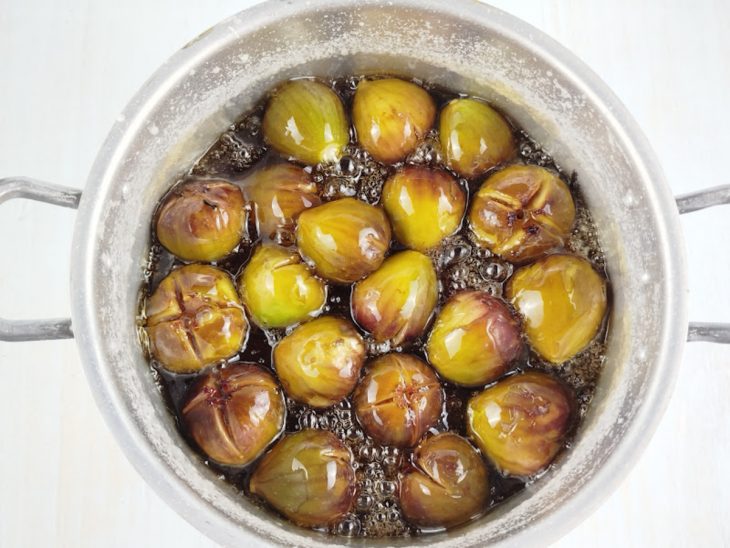 Figos imersos na calda enquanto cozinham.