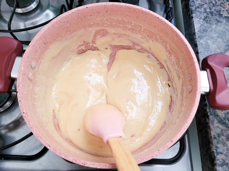 Uma panela contendo doce de leite cremoso.