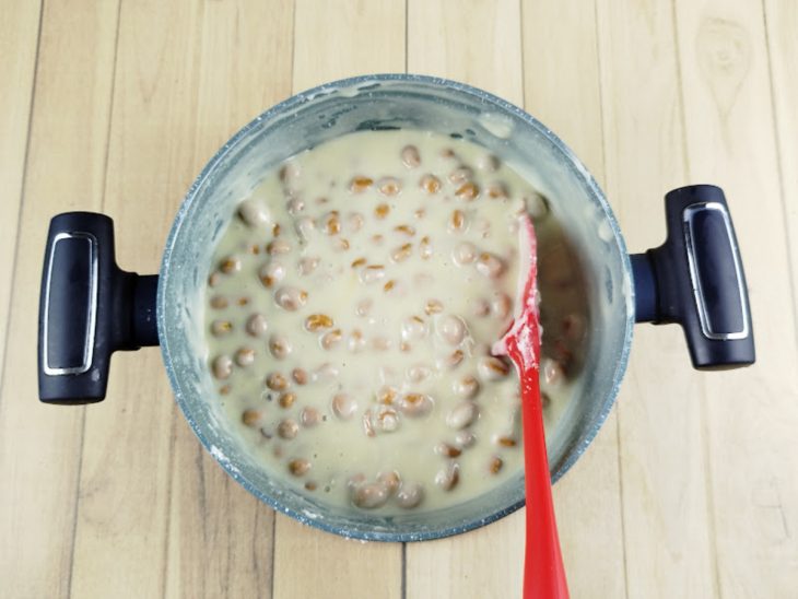 Leite condensado, leite em pó, amendoim e manteiga misturados na panela.