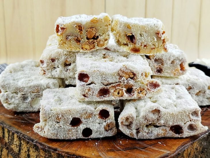 Doce de leite Ninho com amendoim disposto em uma tábua para servir.