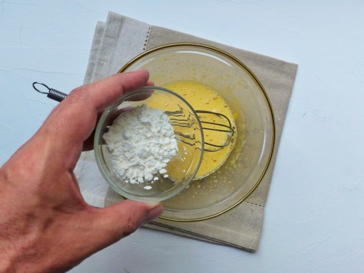 Um recipiente contendo a mistura de gemas, açúcar e amido de milho.