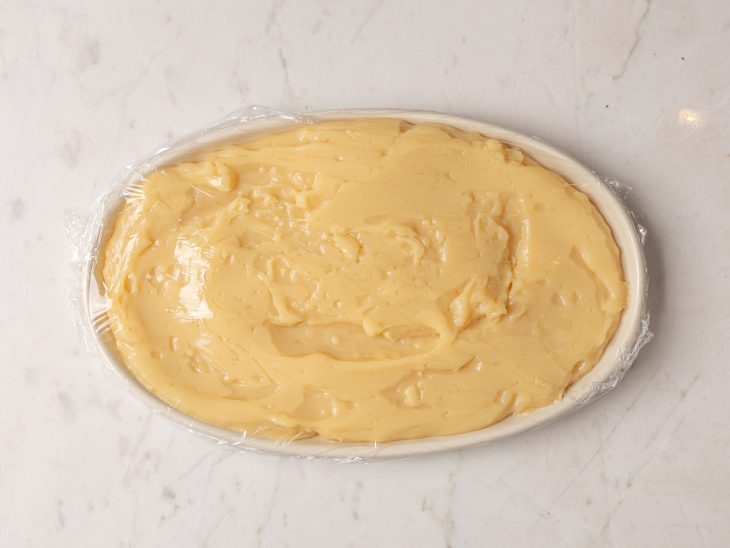 Doce coberto com plástico filme em uma travessa.