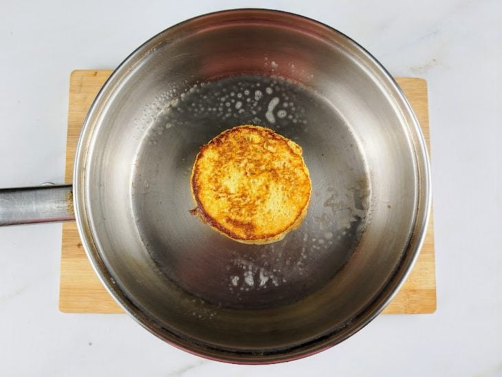 Uma frigideira com o pão a dourar na manteiga.