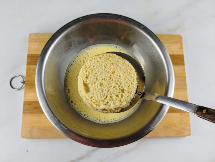 Uma tigela com pães sendo submersos no líquido.