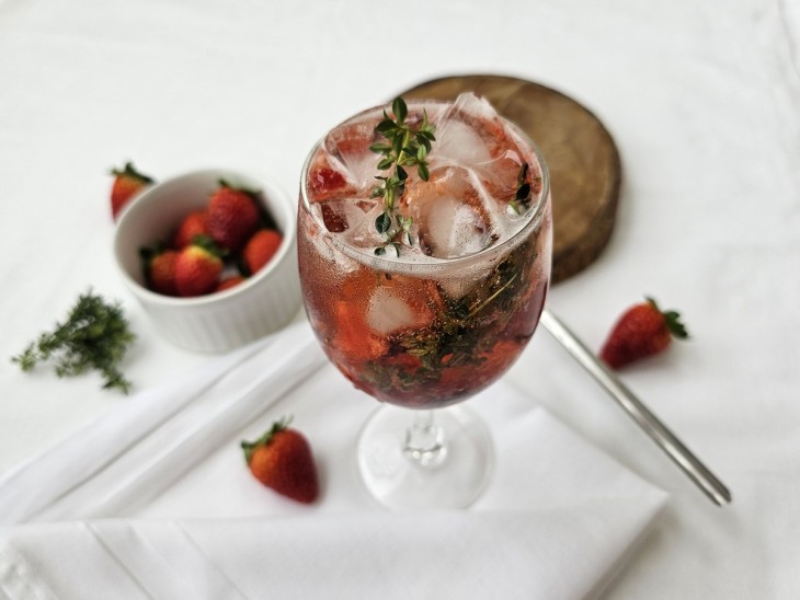 Uma taça contendo drink de morango com espumante.