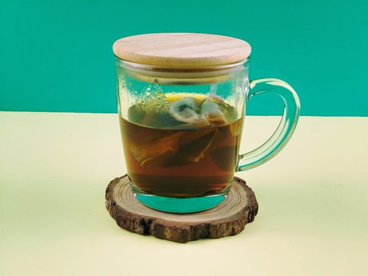 Chá em infusão numa caneca de vidro.
