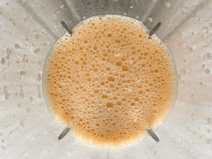 Leite, ovo e caramelo batidos no liquidificador.