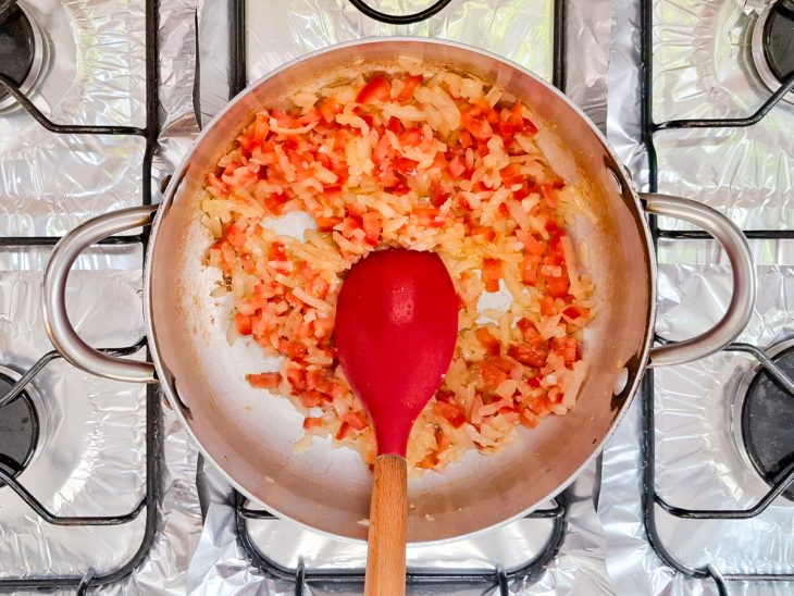 Numa panela, o azeite, a cebola, o alho e o tomate.