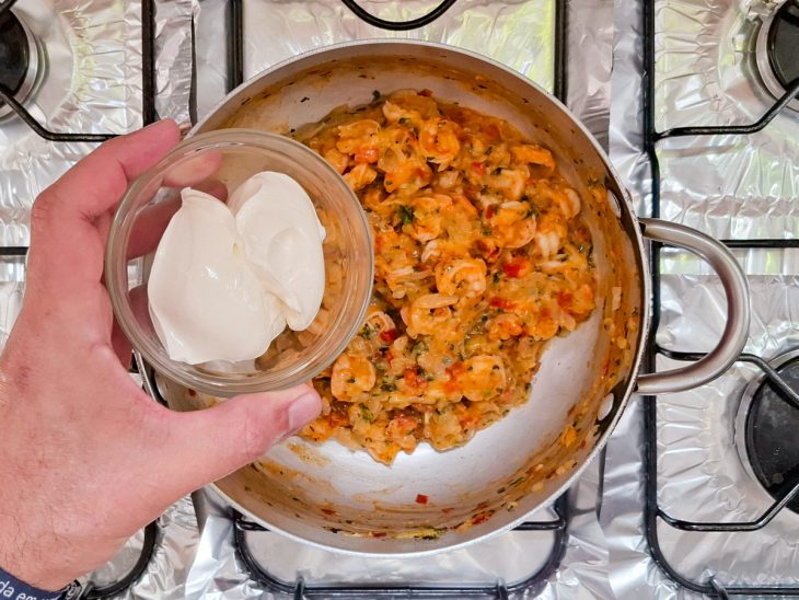 na panela com o recheio, o requeijão sendo adicionado.