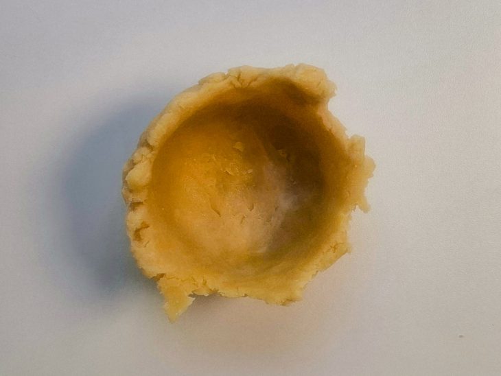 Um pouco de massa transferida para a forminha de empada.