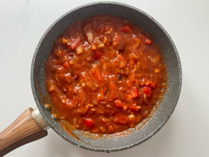 Tomate e extrato de tomate adicionados na frigideira.