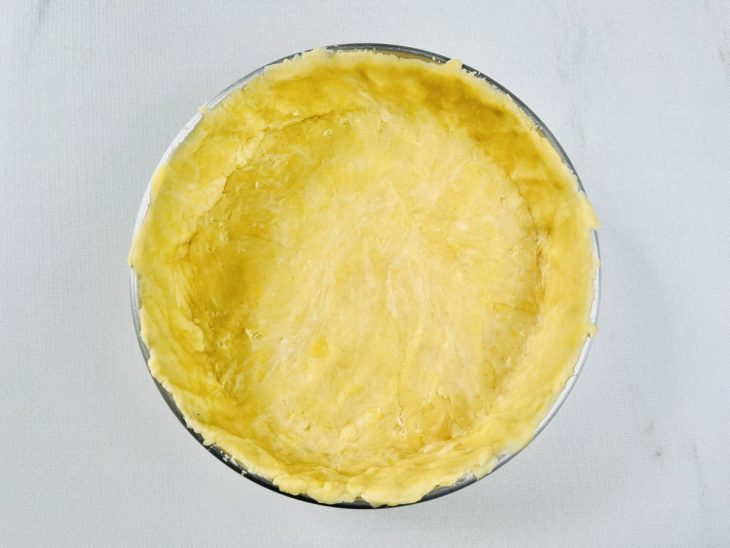 Massa aberta forrando fundo e laterais de forma redonda.