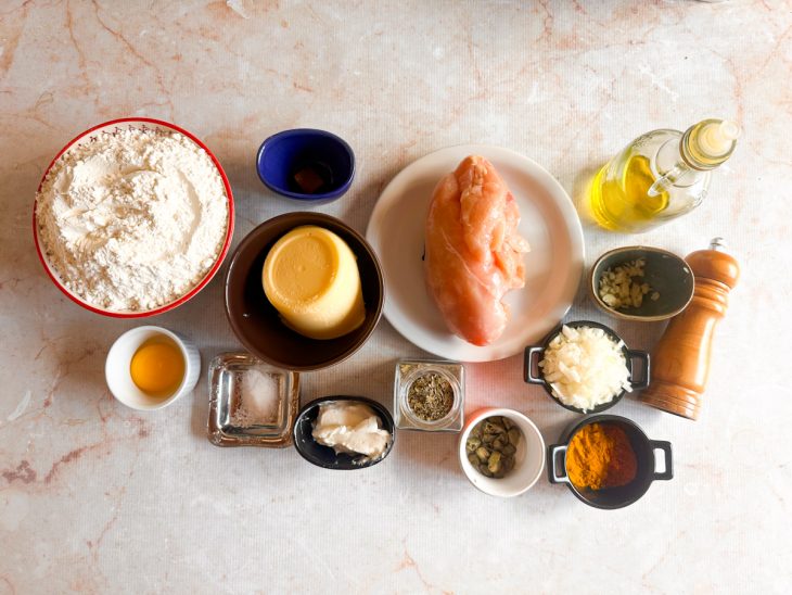 Ingredientes organizados na bancada com alho picado e cebola triturada.