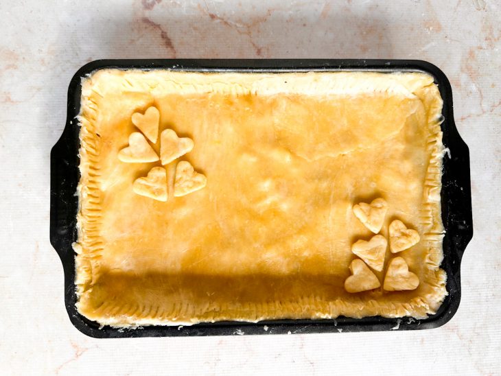 Empadão coberto com a massa aberta e bordas ajustadas.