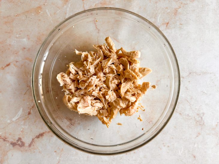 Frango desfiado e água do cozimento reservada.