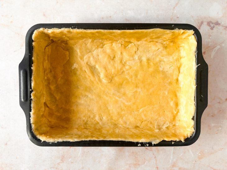 Massa forrando o fundo e as laterais da forma retangular.