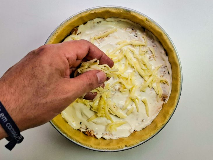 Mussarela salpicada sobre o empadão.