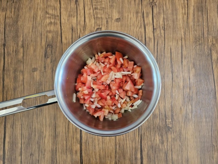 Panela com tomates e temperos.