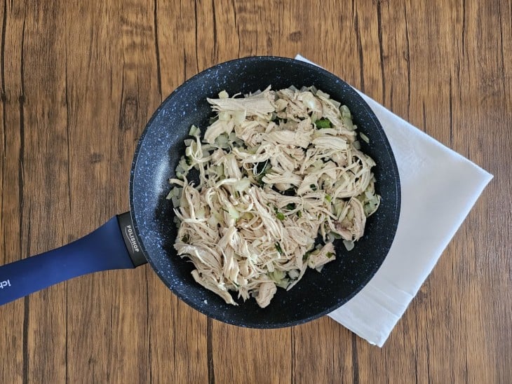 Frigideira com ingredientes do recheio refogando.
