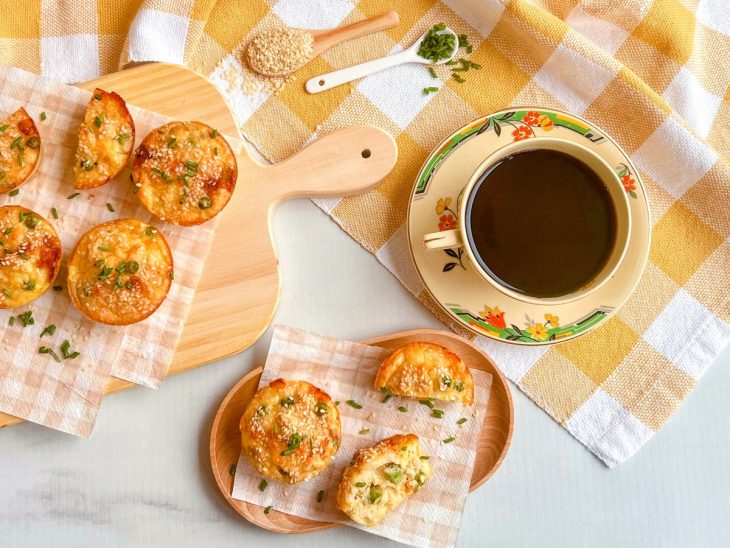 Empadinhas prontas, servidas com café, algumas cortadas ao meio.
