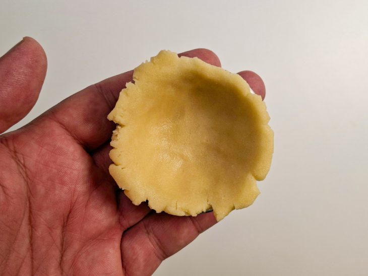 Porção da massa disposta na forminha de empada.