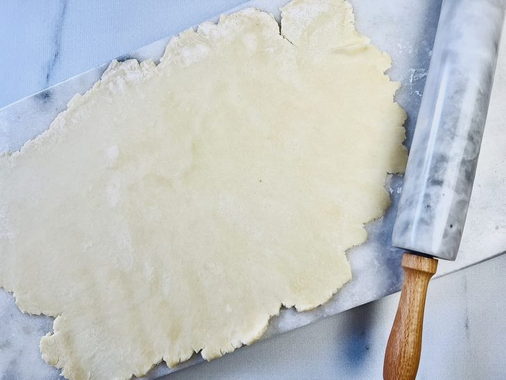 massa de empanada argentina aberta com rolo de macarrão.