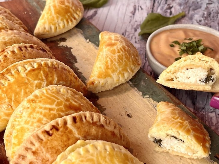 Uma tábua contendo várias empanadas feitas na airfryer.