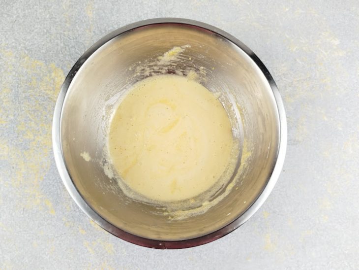 Gemas batidas com açúcar e margarina formando creme claro e homogêneo.