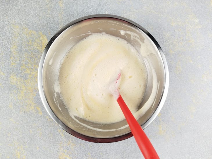 Claras sendo incorporadas delicadamente ao creme de gemas.