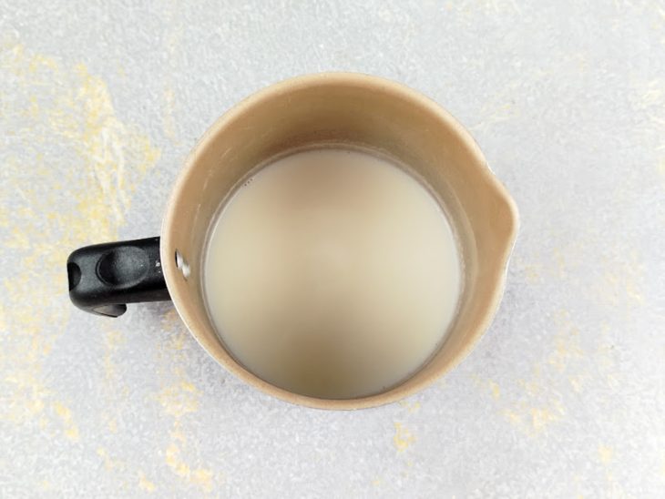 Leite sendo aquecido em panela pequena até ficar bem quente.