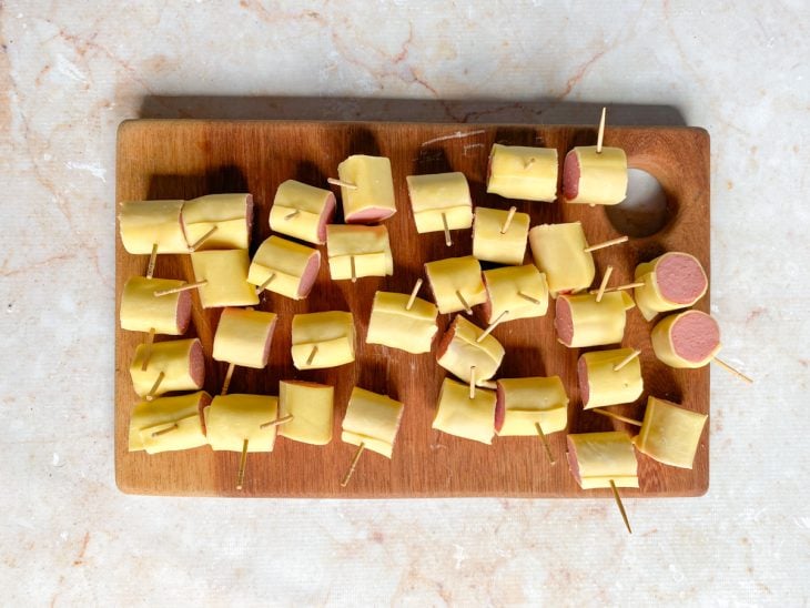 Enroladinhos cortados em 4 pedaços iguais e com palitos de dente.