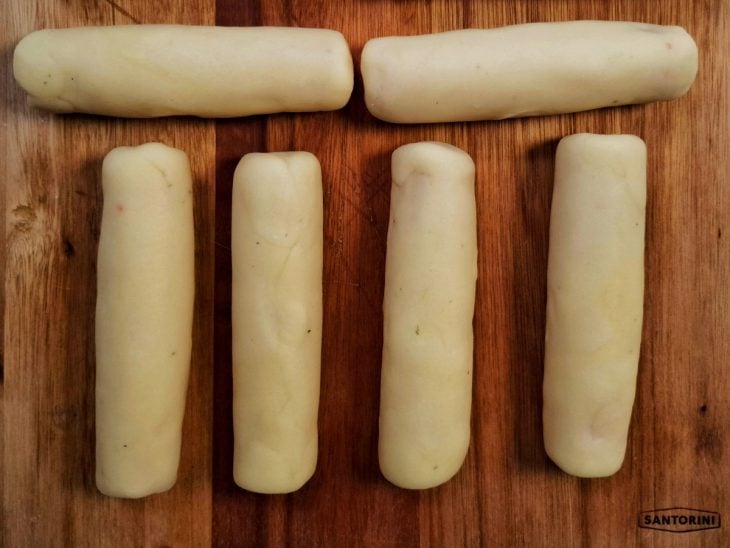 Salsicha enrolada na porção da massa.