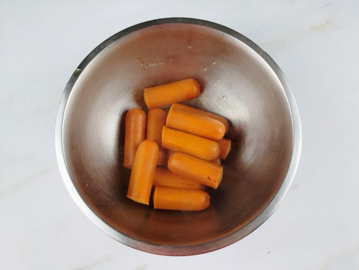 Salsichas cozidas reservadas em uma tigela redonda de inox.
