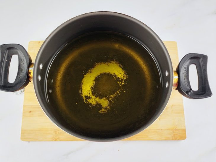 Panela com óleo para fritar os enroladinhos de salsicha simples.