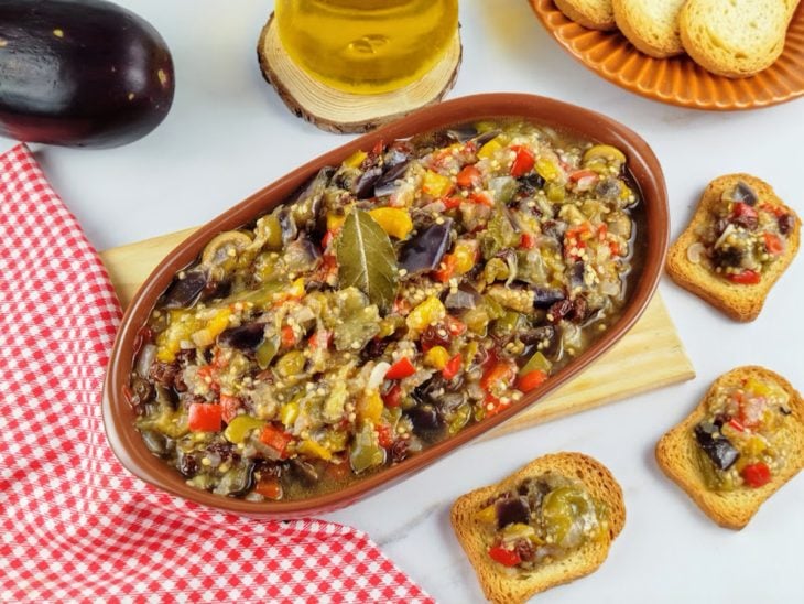 Um recipiente contendo o escabeche de berinjela.