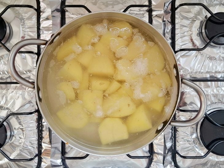 Batatas cozinhando em uma panela com água.