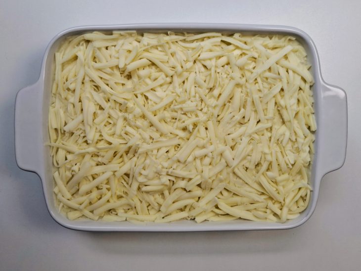 Camada de purê e queijo mussarela adicionados a travessa.