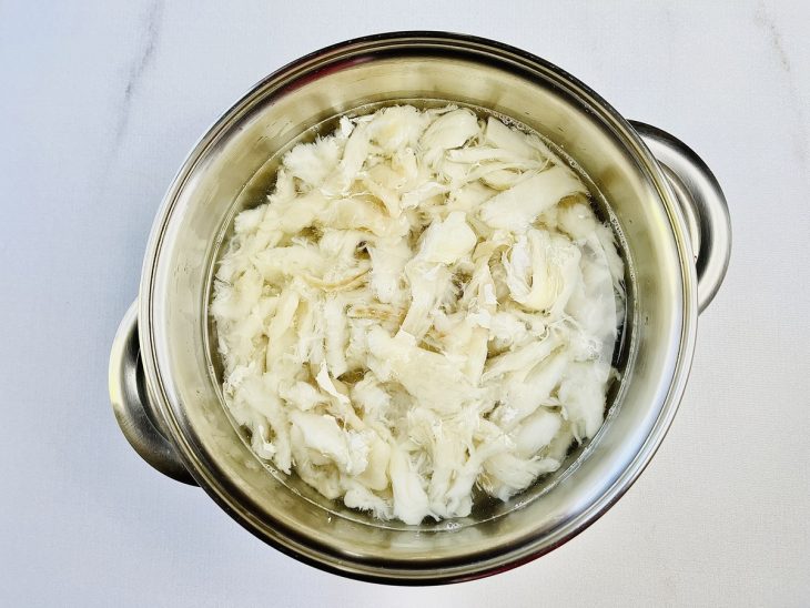 Bacalhau cozinhando em uma panela com água.