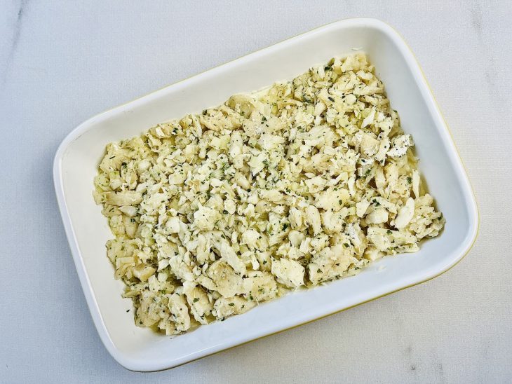 Recheio de bacalhau adicionado sobre a camada de purê.