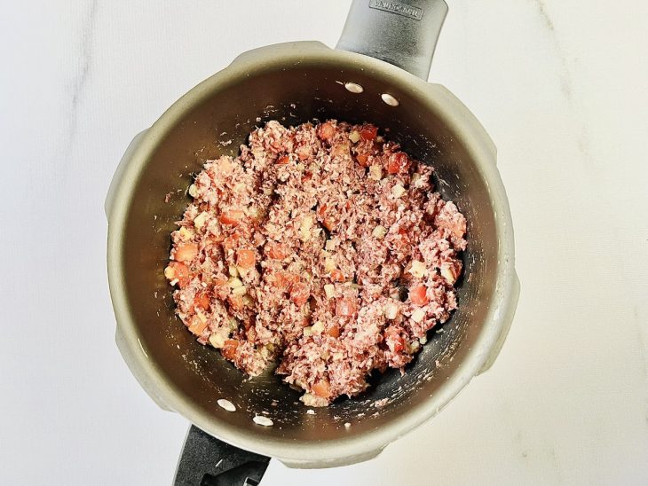 carne seca desfiada e temperos refogados.