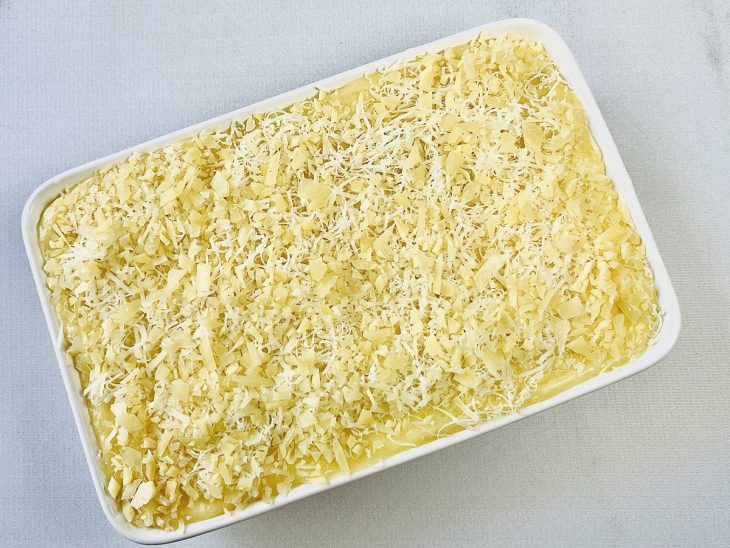 queijo espalhado por cima de todo o escondidinho para finalização com gratinação.